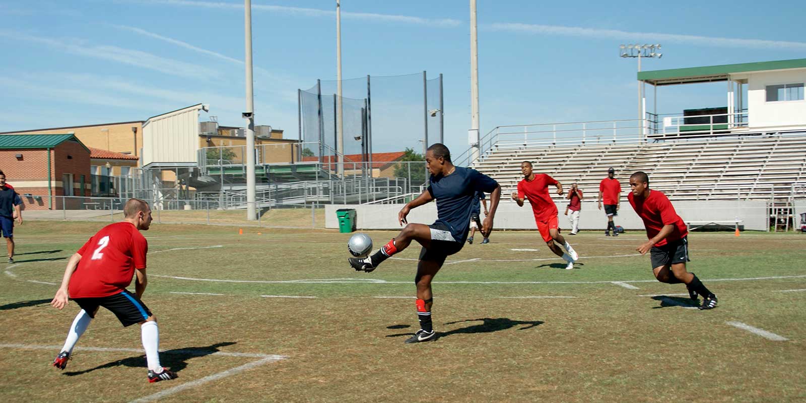 A group of men playing soccer on an open field.