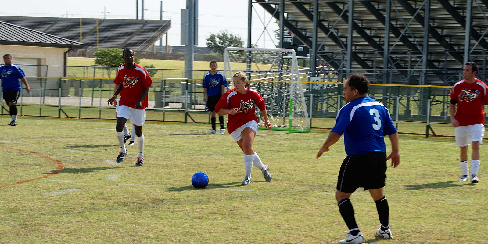 A group of people playing soccer on a field.